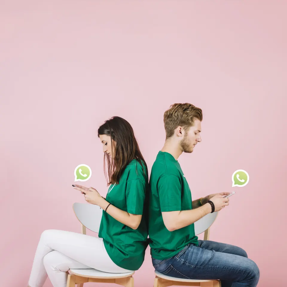 Foto de archivo de dos personas usando WhatsApp en el celular